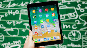 Image of an iPad in a hand.  Green and white backround.