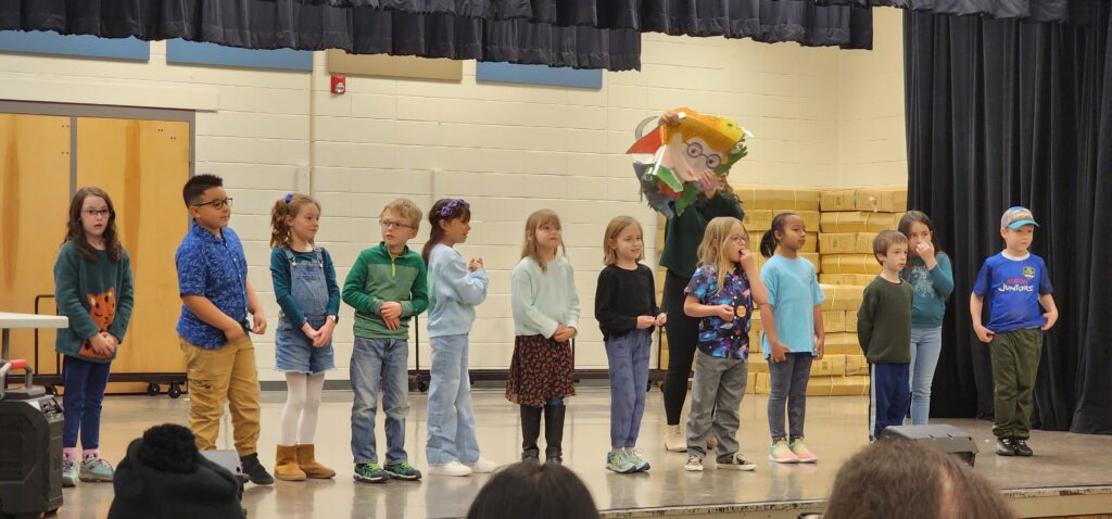 Photograph of Sanborn 2nd graders singing on a stage.