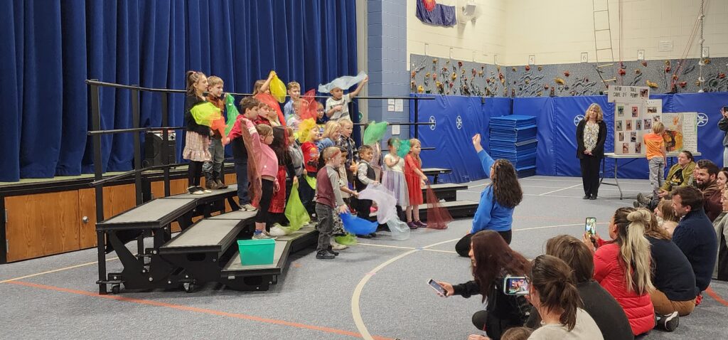 Photograph of Kindergartners singing on risers.